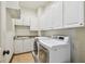 Laundry room with white cabinets, sink and modern appliances at 4313 W Beachway Dr, Tampa, FL 33609