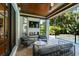 Inviting covered patio features comfortable seating, a mounted television, and serene views of the lush backyard and sparkling pool at 4313 W Beachway Dr, Tampa, FL 33609