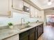 Kitchen with sleek granite countertops, stainless steel sink, and stylish black cabinetry at 4405 Vieux Carre Cir # 4405, Tampa, FL 33613