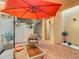 Charming outdoor patio featuring brick flooring, comfortable seating, and a vibrant orange umbrella for shade at 4405 Vieux Carre Cir # 4405, Tampa, FL 33613