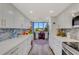 Modern kitchen with white cabinets, stone countertops, and a workspace overlooking outdoor views at 4705 1St Ne St # 326, St Petersburg, FL 33703