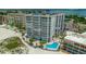 Scenic aerial view showcasing a beachfront condo near pool and tennis courts, with mature landscaping at 4950 Gulf Blvd # 409, St Pete Beach, Fl, FL 33706