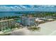 Aerial view showcasing the condo's beach access, tennis courts, lush landscaping, and community pool at 4950 Gulf Blvd # 409, St Pete Beach, Fl, FL 33706