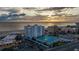 Beautiful sunset aerial view of beachfront condos with tennis courts offering convenient beach access at 4950 Gulf Blvd # 409, St Pete Beach, Fl, FL 33706