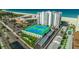 Aerial view of condos featuring well maintained tennis courts and community pool near the beach at 4950 Gulf Blvd # 409, St Pete Beach, Fl, FL 33706