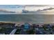 Aerial view featuring condos with beach access and a tennis court near the ocean at 4950 Gulf Blvd # 409, St Pete Beach, Fl, FL 33706