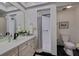 Bathroom featuring a vanity, an elongated toilet, a shower with curtain, and a large mirror at 4950 Gulf Blvd # 409, St Pete Beach, Fl, FL 33706