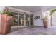 Building entryway with large sliding doors, planters, and stylish stone floors at 4950 Gulf Blvd # 409, St Pete Beach, Fl, FL 33706