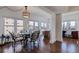 Dining area with hardwood floors, a round table with seating, and multiple windows with neighborhood views at 4950 Gulf Blvd # 409, St Pete Beach, Fl, FL 33706