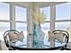Charming dining area with a glass table, seating for two, and views of the ocean and sandy beach at 4950 Gulf Blvd # 409, St Pete Beach, Fl, FL 33706