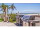 Community grilling station with stainless steel gas grills, lush landscaping and ocean views at 4950 Gulf Blvd # 409, St Pete Beach, Fl, FL 33706