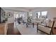 Bright living room featuring a large clock, hardwood floors, and comfortable seating arrangement at 4950 Gulf Blvd # 409, St Pete Beach, Fl, FL 33706