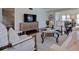 Cozy living room with a woven console, large TV, plush seating, and accent chairs around a glass table at 4950 Gulf Blvd # 409, St Pete Beach, Fl, FL 33706