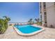 Beachside pool with lounge chairs and view of the ocean with the condominium building in the background at 4950 Gulf Blvd # 409, St Pete Beach, Fl, FL 33706