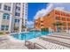 Inviting pool with sun loungers with condo buildings and tropical landscaping in background at 4950 Gulf Blvd # 409, St Pete Beach, Fl, FL 33706