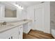 Bright bathroom with dual sinks, white cabinets, quartz counters, and wood-look flooring at 5526 Southernview Dr, Zephyrhills, FL 33541