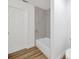 Bathroom featuring bathtub, modern gray marble tiling, and wood-look flooring at 5526 Southernview Dr, Zephyrhills, FL 33541