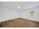 Bedroom features wood-look floors, neutral paint, recessed lighting, and a window at 5526 Southernview Dr, Zephyrhills, FL 33541