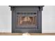 Close-up of a dark grey fireplace with a mesh screen and decorative corbels at 5526 Southernview Dr, Zephyrhills, FL 33541