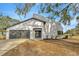 Beautifully landscaped front exterior of a home with a gray garage and a distinctive curved architectural feature at 5526 Southernview Dr, Zephyrhills, FL 33541