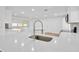 Bright, modern kitchen featuring an island, white cabinets, quartz countertops and stainless steel appliances at 5526 Southernview Dr, Zephyrhills, FL 33541