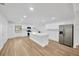 Bright, open kitchen with white cabinets, stainless steel appliances, and a large island at 5526 Southernview Dr, Zephyrhills, FL 33541