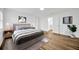 Bright bedroom featuring wood floors, ensuite bathroom, and neutral decor for a relaxing retreat at 5526 Southernview Dr, Zephyrhills, FL 33541