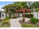Backyard featuring a pergola, lush tropical landscaping, stone pavers, mulch beds and manicured lawn at 601 Patricia Ave # A, Dunedin, FL 34698
