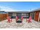 Backyard featuring stone pavers, a fire pit, red Adirondack chairs, lawn, and sliding glass doors at 601 Patricia Ave, Dunedin, FL 34698