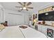 Bright bedroom features a ceiling fan, white walls, and a cabinet-dresser with 'Queen' decor at 601 Patricia Ave, Dunedin, FL 34698