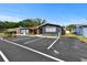 Single-story building with a parking lot, bright yellow door, and covered patio area at 601 Patricia Ave, Dunedin, FL 34698