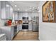 Renovated kitchen with stainless steel appliances, granite countertops, and modern gray cabinetry at 601 Patricia Ave, Dunedin, FL 34698