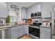 Kitchen with stainless steel appliances, light gray cabinets, and light granite countertops at 601 Patricia Ave, Dunedin, FL 34698