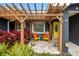 Comfortable patio with decorative plants and bright yellow seating that accents the vibrant front door at 601 Patricia Ave, Dunedin, FL 34698