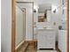 Bathroom with shower stall, modern vanity, mirror, stacked washer/dryer unit and wooden trim at 601 Patricia Ave, Dunedin, FL 34698