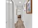 Bright hallway featuring hardwood floors, white walls, and a glimpse into a stylishly decorated room at 601 Patricia Ave, Dunedin, FL 34698