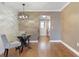 Dining area with hardwood floors, designer lighting, a glass table, and direct access to the kitchen at 6015 19Th N St # 311, St Petersburg, FL 33714