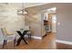 Dining area with hardwood floors, designer lighting, a glass table, and direct access to the kitchen at 6015 19Th N St # 311, St Petersburg, FL 33714