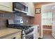 Cozy kitchen featuring stainless steel appliances, granite countertops, and a decorative tile backsplash at 6015 19Th N St # 311, St Petersburg, FL 33714
