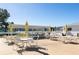 View of the patio area with umbrella tables, chairs and a lake with fountain in the background at 6015 19Th N St # 311, St Petersburg, FL 33714