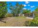 A view of the home's backyard, showcasing green grass and a screened in back porch at 707 24Th Sw St, Largo, FL 33770