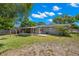 Backyard view featuring a cozy screened-in porch, pergola, and fenced perimeter at 707 24Th Sw St, Largo, FL 33770