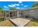 A view of the backyard featuring a screened-in porch with stone pavers and exterior wall at 707 24Th Sw St, Largo, FL 33770