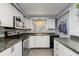 Well-maintained kitchen featuring white cabinets, modern appliances, granite countertops, and tile backsplash at 707 24Th Sw St, Largo, FL 33770