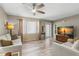 A modern living room features hardwood floors, a ceiling fan, neutral paint, and plenty of natural light at 707 24Th Sw St, Largo, FL 33770