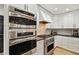 Gourmet kitchen featuring stainless steel double ovens, gas range, stylish cabinetry, and sleek countertops at 7109 Pelican Island Dr, Tampa, FL 33634