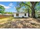 The backyard includes a freshly painted house, mature trees, and a fire pit at 8504 N 17Th St, Tampa, FL 33604