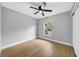 This light and airy bedroom has wood-look flooring, a ceiling fan, and a window at 8504 N 17Th St, Tampa, FL 33604