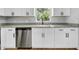Updated kitchen with stainless steel dishwasher, white cabinets, and granite countertop at 8504 N 17Th St, Tampa, FL 33604