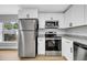 Modern kitchen featuring stainless steel appliances, granite countertops, and white cabinets at 8504 N 17Th St, Tampa, FL 33604
